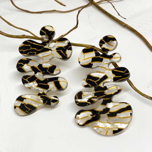 Coral - Patterned Gold, White, and Black Shape